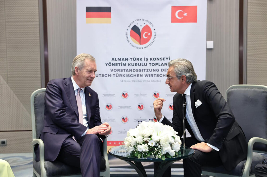 Gesprächsszene beim deutsch-türkischen Wirtschaftstreffen in Istanbul vor Banner des Deutsch-Türkischen Wirtschaftsrats.